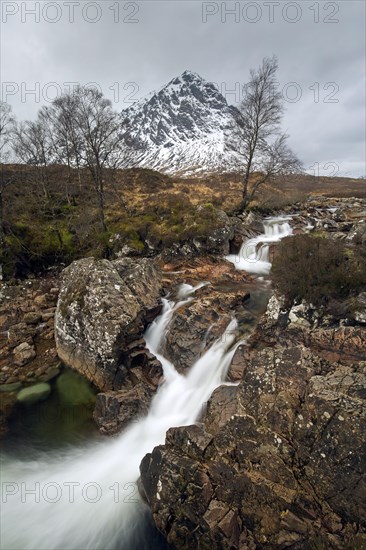 Scottish mountain Buachaille Etive Mor and waterfall on River Coupall in winter in Glen Etive near Glencoe in the Highlands of Scotland