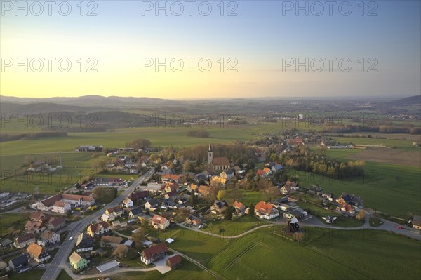 Aerial view of the district of Kottmarsdorf in the Saxon municipality of Kottmar and the Kottmarsdorf mill against the mountainous landscape of Upper Lusatia. Kottmar
