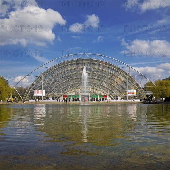 Glass hall with reflection in the water basin in front of the main entrance to the Leipzig Trade Fair