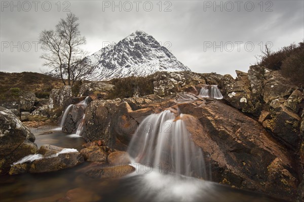 Scottish mountain Buachaille Etive Mor and waterfall on River Coupall in winter in Glen Etive near Glencoe in the Highlands of Scotland