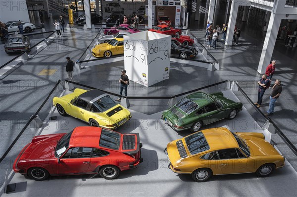 Porsche 911s lined up for presentation in an exhibition hall