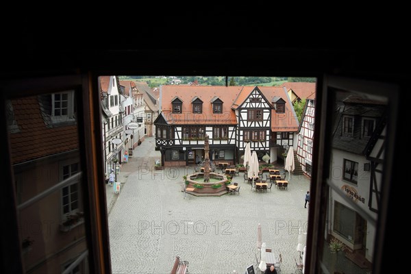 View through open window of the town hall on market place with half-timbered house