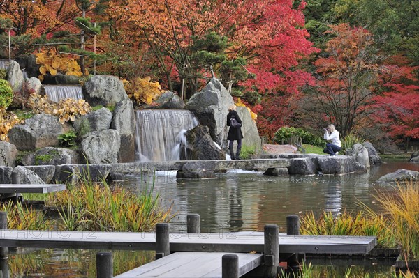 Tourists visiting Japanese garden in autumn at Hasselt