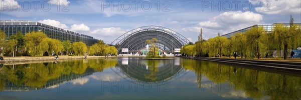 Glass hall with reflection in the water basin in front of the main entrance to the Leipzig Trade Fair