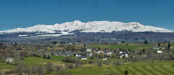 Regional natural park of the Volcanoes of Auvergne. View on the village of Saint Genes Champespe and the Monts Dore in winter. Puy de Dome department. Auvergne-Rhone-Alpes. France