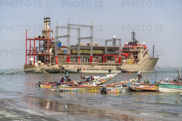 The floating power plant Karadeniz Powership Faruk Bey and fishing boats on the coast near Banjul