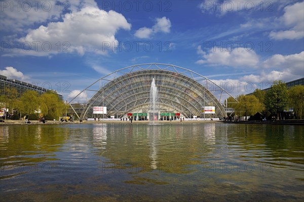 Glass hall with reflection in the water basin in front of the main entrance to the Leipzig Trade Fair