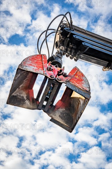 Excavator shovel in blue sky on construction site