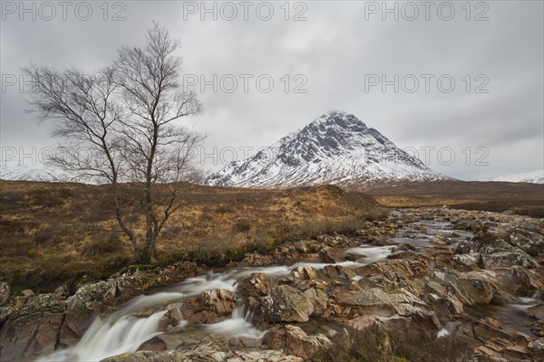 Scottish mountain Buachaille Etive Mor and waterfall on River Coupall in winter in Glen Etive near Glencoe in the Highlands of Scotland