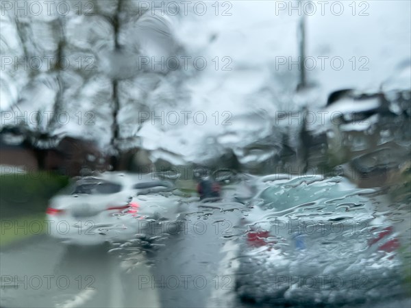 View through windscreen of car in heavy rain in dangerous situation in road traffic at car in front