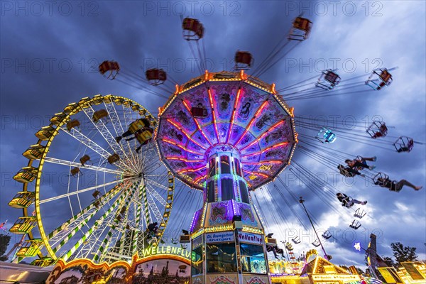 Ferris wheel and historic chain carousel in the evening