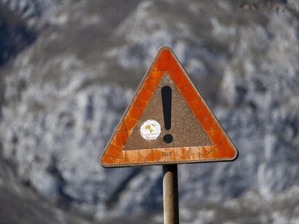 Weathered traffic sign with exclamation mark