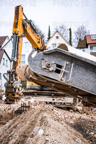 Recycling plant on demolition site with yellow excavator