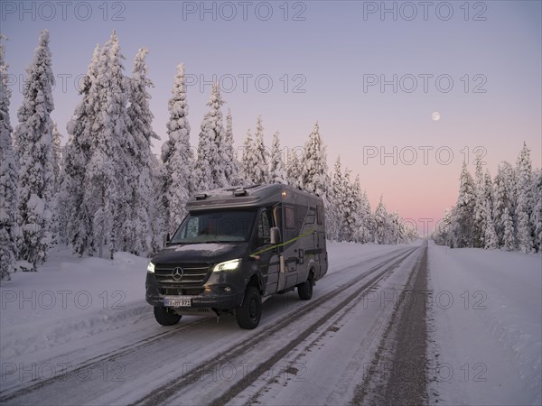 Travelling by motorhome in wintry Lapland at dawn