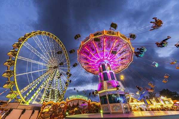 Ferris wheel and historic chain carousel in the evening