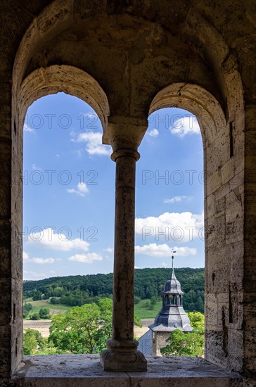 View through a window of the west tower of the Romanesque monastery ruins of St. Wigbert at surrounding structures in the village of Goellingen near Bad Frankenhausen in Kyffhaeuserland