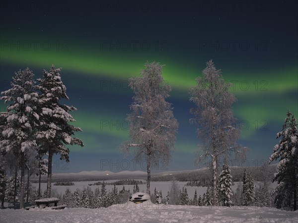 Northern Lights above Lake Saerkijaervi with a view of the mountains of Pallas Yllaestunturi National Park