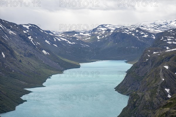 View of Lake Gjende and snowy mountains