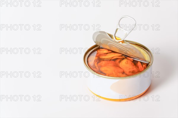 Close-up of an open can of mussels in olive oil isolated on a white background