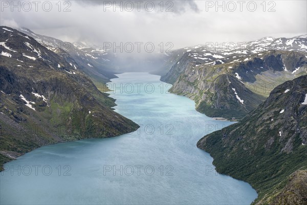 View of Lake Gjende and snowy mountains