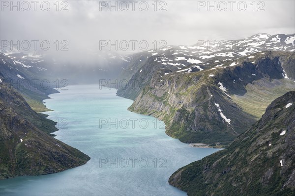 View of Lake Gjende and snowy mountains