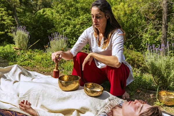 Woman doing sound massage with singing bowls. Sound therapy