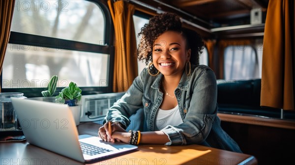 Happy african american young adult female enjoying working remotely inside her RV camper trailer