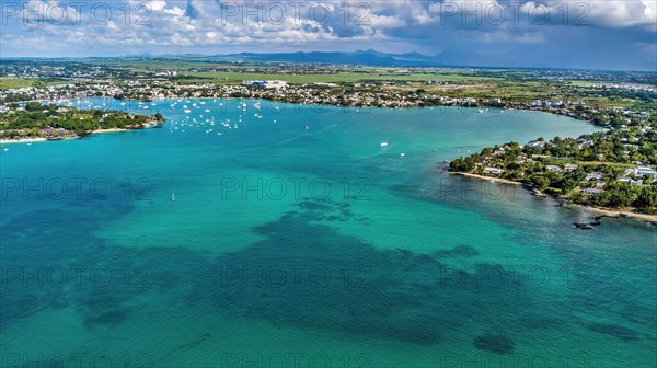 Aerial view from bird's eye view of large sea bay Grand Baie with pleasure boats motor yachts sailboats anchored in sheltered bay