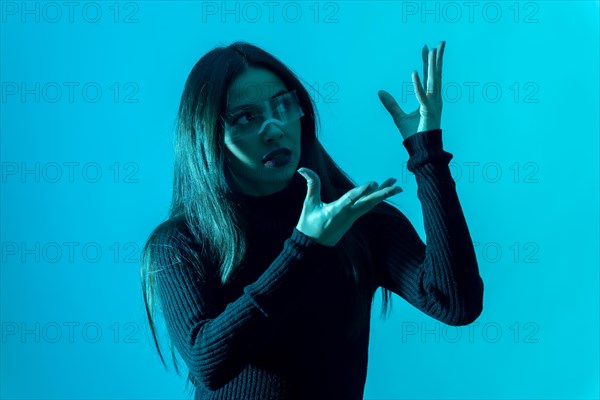 Technology concept. Portrait of woman in futuristic glasses with led light on a blue background