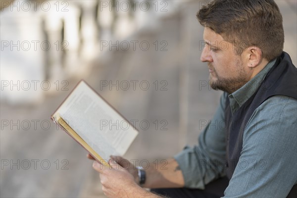 Business man reading a book in a park