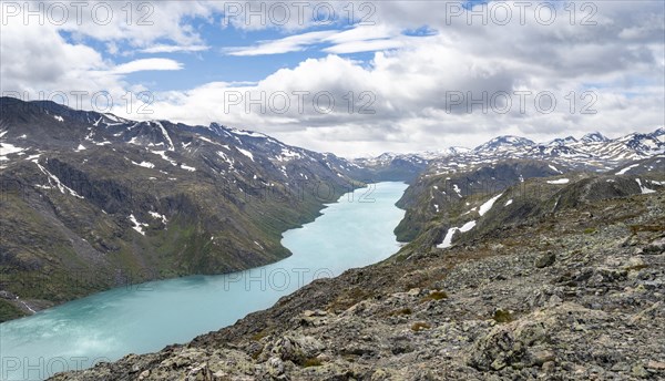 View of Lake Gjende and snowy mountains