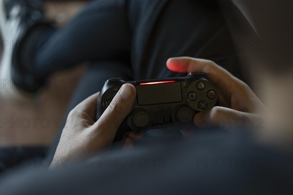 Close-up of an adult man's hands holding a joystick while playing a video game on a console