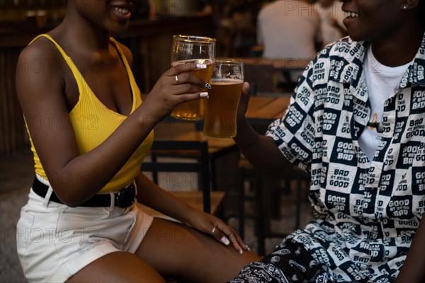 Young afro couple in a night club toasting with beer. Short shot