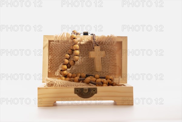 Close-up of a wooden box with a Christian crucifix wrapped in a raffia cloth isolated on a white background
