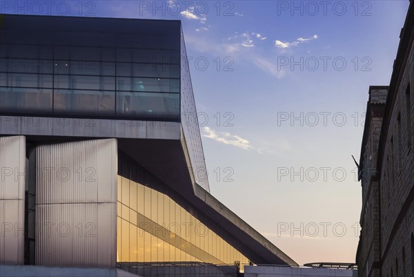 Facade of Acropolis museum facing Acropolis reserch center mirroring the sunset