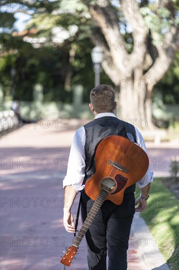 Rear view of a guitarist walking