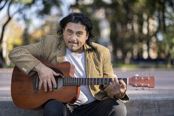 Flamenco guitarist sitting on some stairs performing