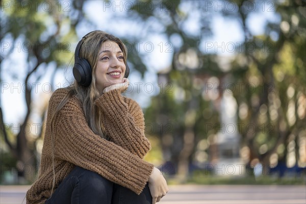 Dreamy and touched tender blonde woman listening music in a park