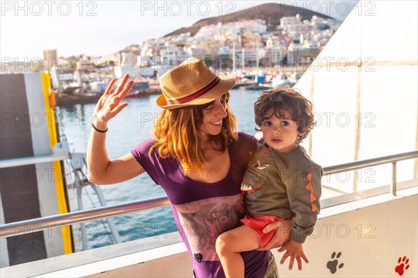 Mother and son on vacation on the ferry and the city of Los Cristianos in the background on the island of Tenerife. Ferry coming from La Gomera