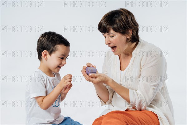 Happy mother's day! Son congratulating his mom and giving her a gift. Studio portrait on white background