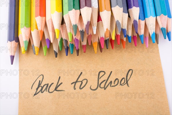 Color pencils and back to school title on a notebook