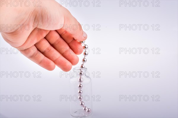 Little perfume glass bottle in hand on a white background