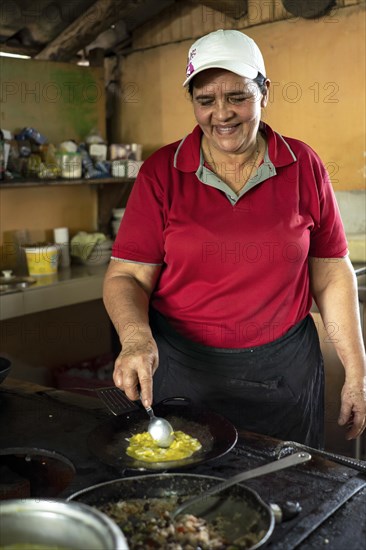 Woman friendly cooks traditional Costa Rican lunch of Gallo Pinto