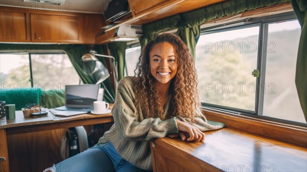 Happy mixed-race young adult female enjoying working remotely inside her RV camper trailer