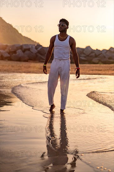 Portrait of black ethnic model enjoying summer vacation by the sea wearing a tank top