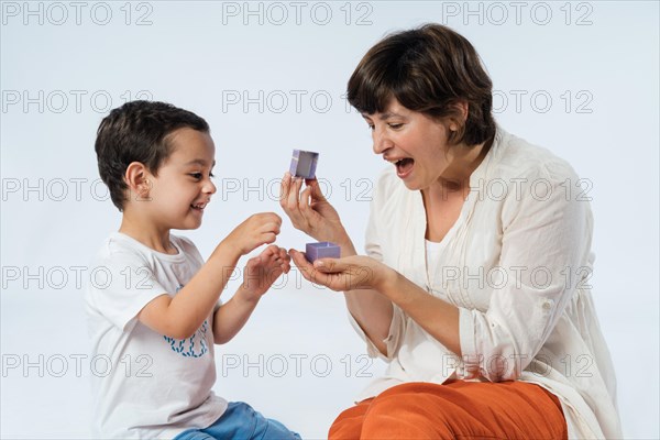 A young child surprises his mother with a birthday gift. Mum's birthday. Mother's day concept. Boy expressing gratitude and love on mother's day