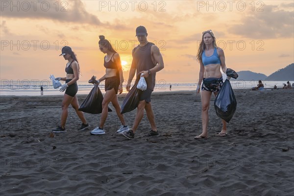 Concepto de voluntariado. Jovenes recogiendo basura en la playa. Ecology concept and World Environment Day. Save earth concept