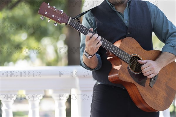 Professional guitarist plays guitar outdoors. Musician plays a classical guitar in the park