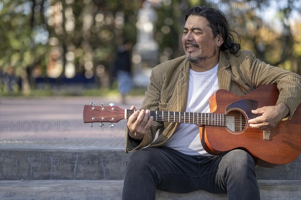 Flamenco guitarist sitting on some stairs performing