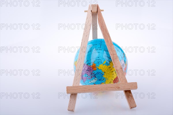 Little model globe put under tripod on a white background